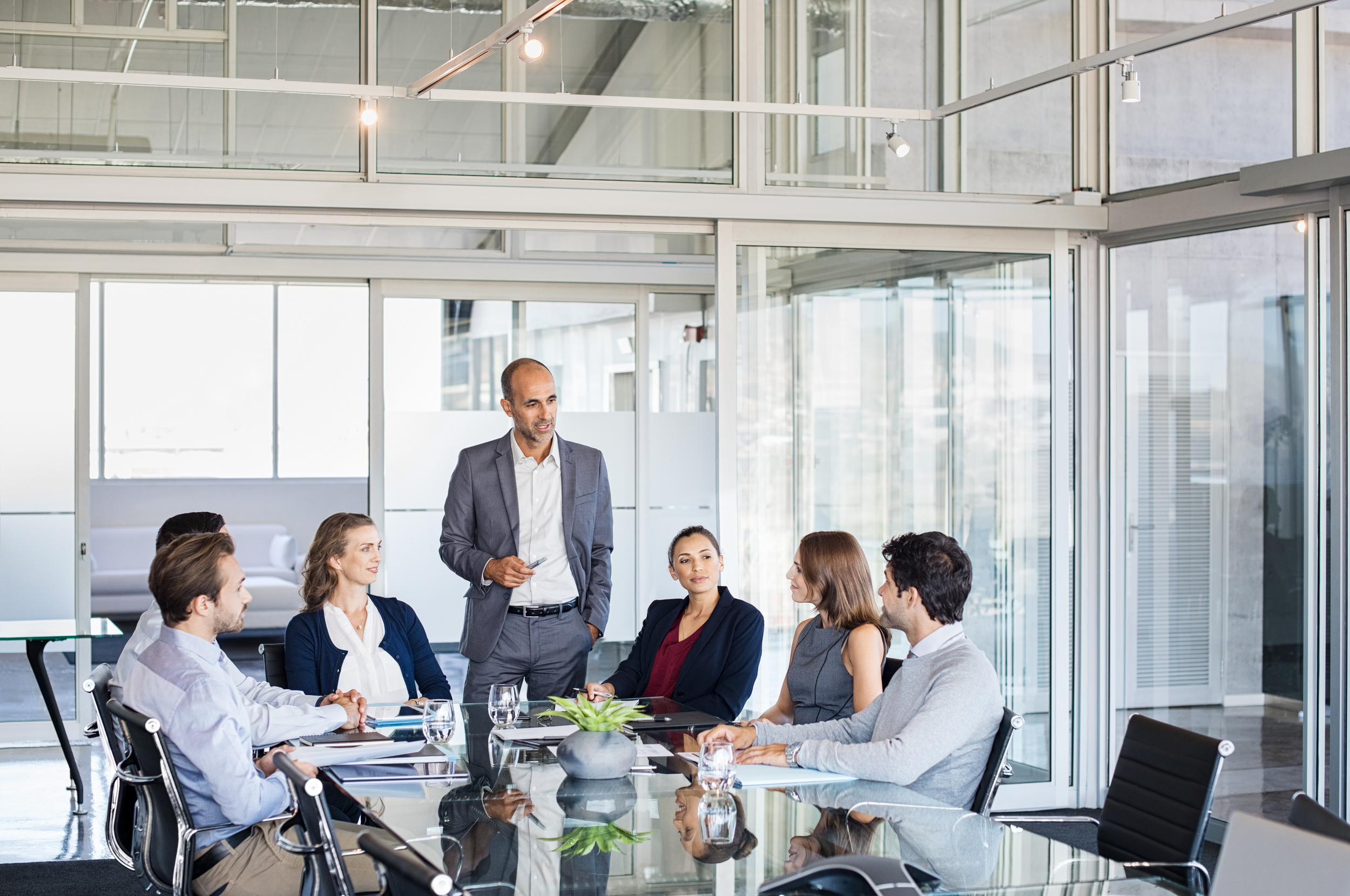 Investment committee meeting in a glass-walled office